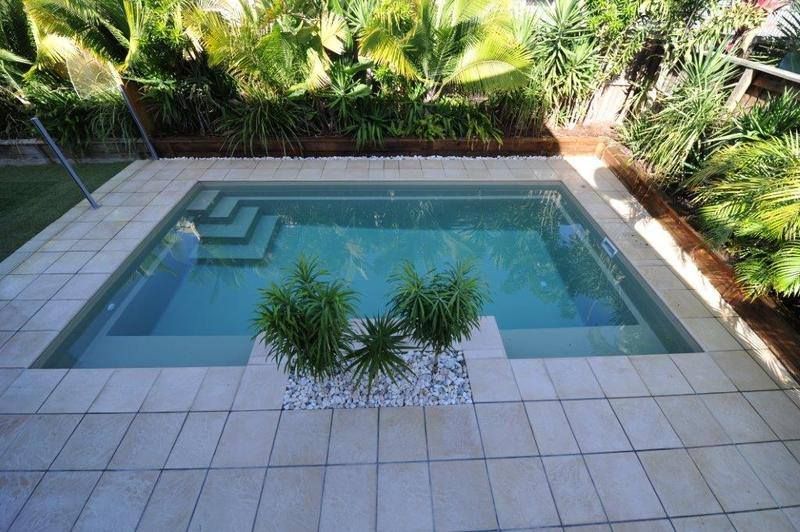 A Large Blue Swimming Pool With Stairs in Front of a House — Sun City Pools In Hyde Park, QLD