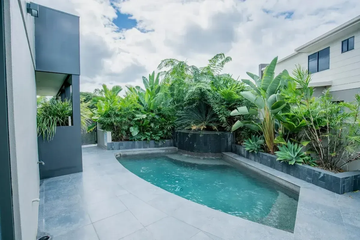 A Small Swimming Pool is Sitting on Top of a Lush Green Lawn — Sun City Pools In Hyde Park, QLD