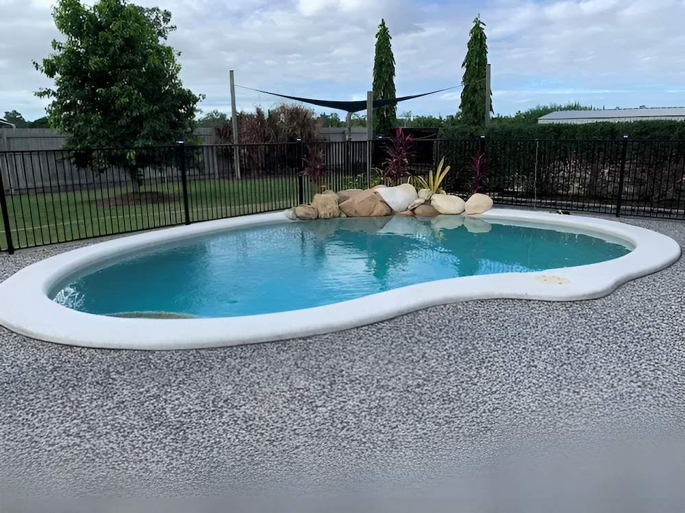 A Swimming Pool With a Walkway Leading to It — Sun City Pools In Hyde Park, QLD