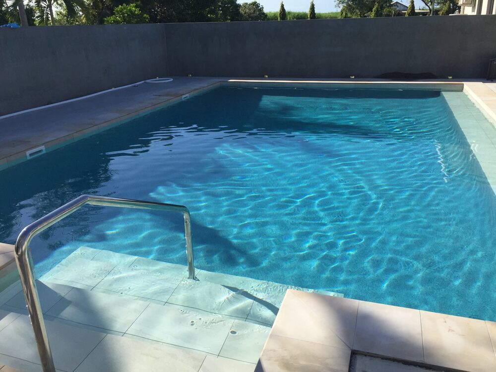 A Large Swimming Pool With a Staircase Leading to It — Sun City Pools In Hyde Park, QLD