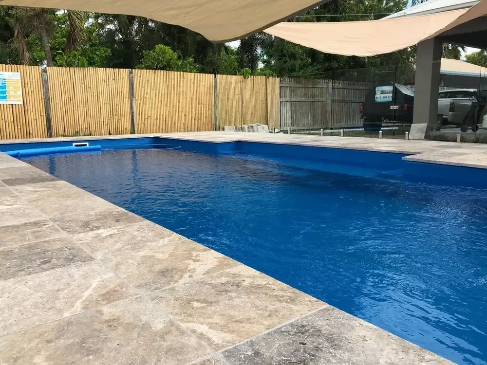 A Large Blue Swimming Pool With a Canopy Over It — Sun City Pools In Hyde Park, QLD