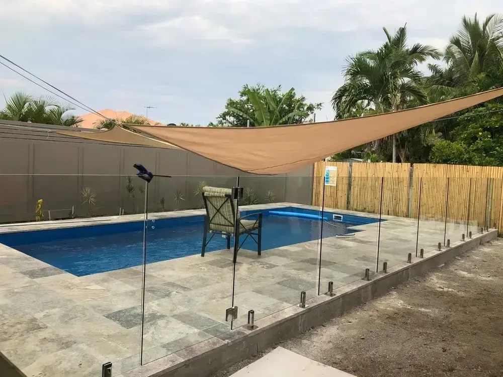 A Large Swimming Pool With a Fence Surrounding It — Sun City Pools In Hyde Park, QLD