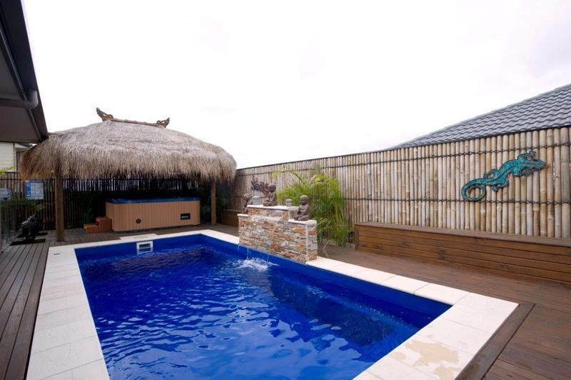 A House With a Large Swimming Pool in Front of It — Sun City Pools In Hyde Park, QLD