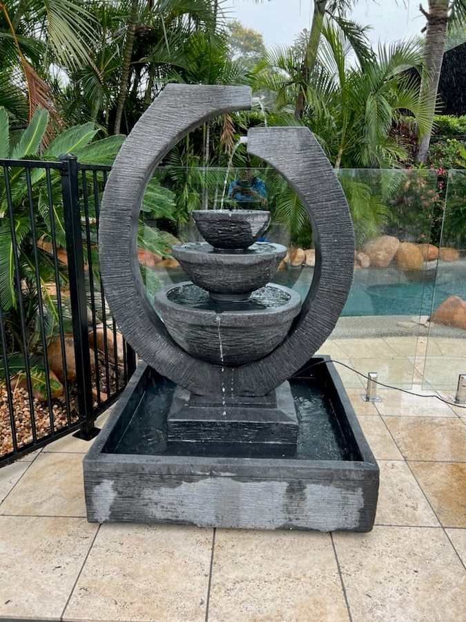 A Large Fountain is Sitting on a Tiled Floor Next to a Pool — Sun City Pools In Hyde Park, QLD