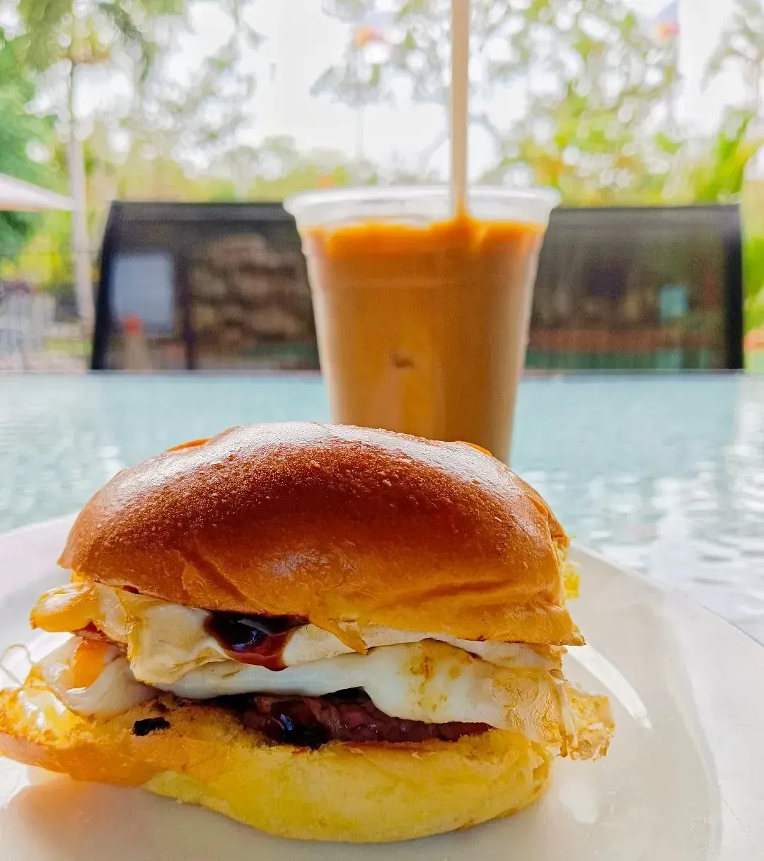 A Close Up Of A Sandwich On A Plate With A Cup Of Coffee In The Background — Heritage Resort in Nanum, QLD