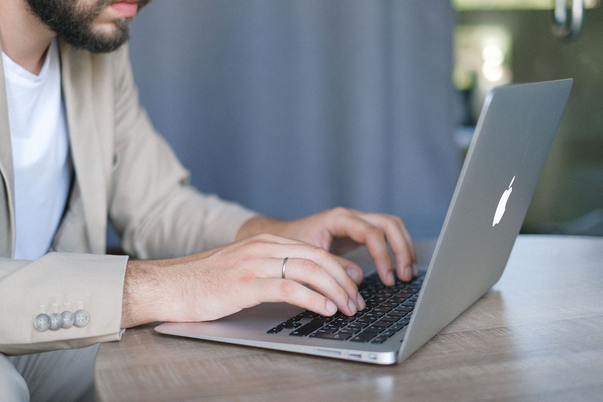 Person typing on a laptop at a table in a softly lit room