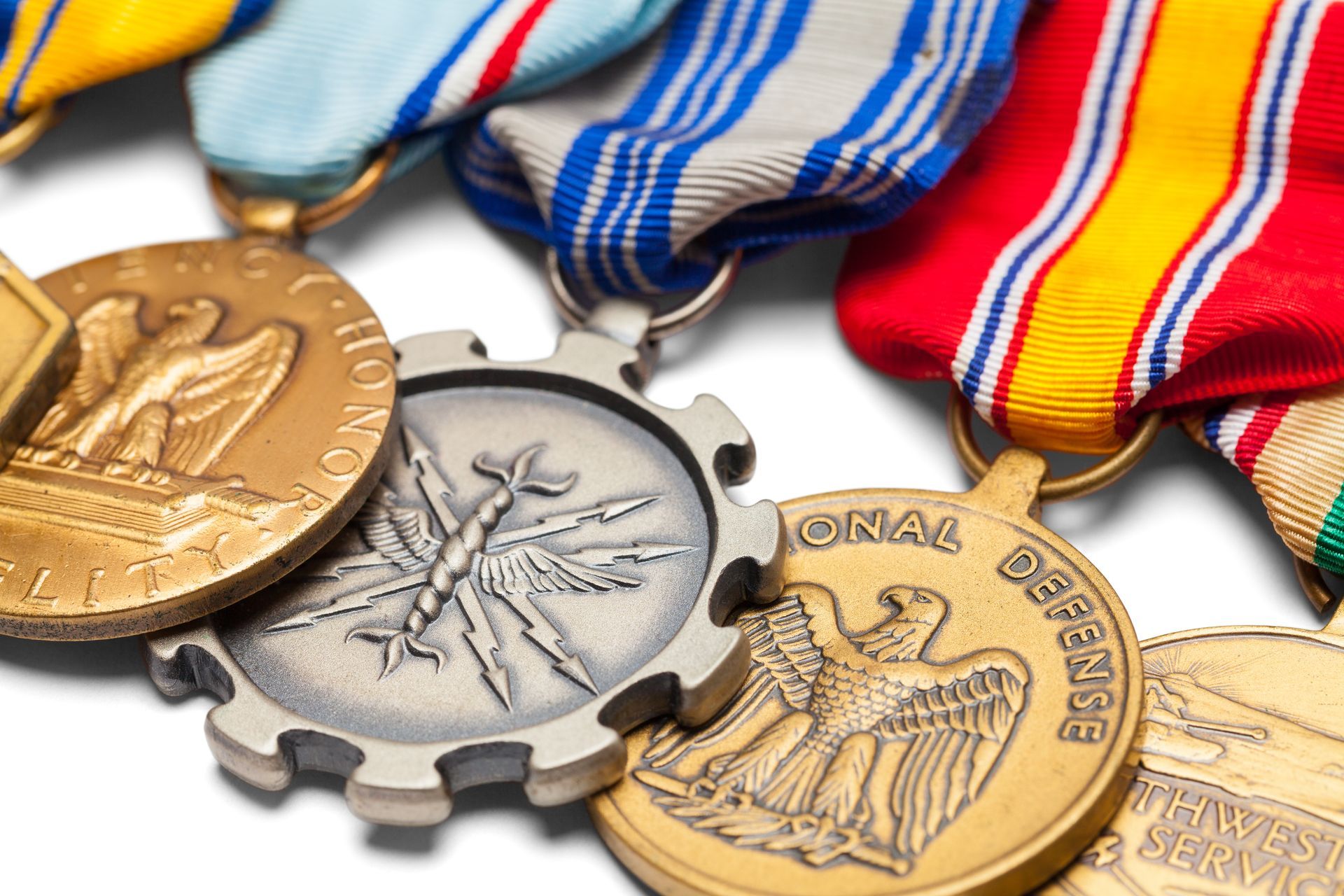 Three military medals with colorful ribbons on a white background