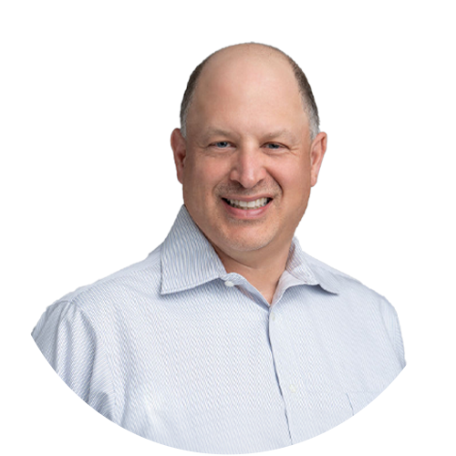 A bald man in a white shirt is smiling for the camera.