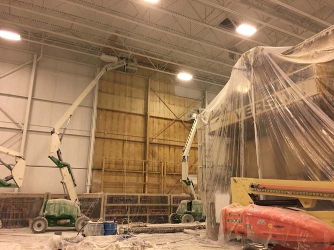 A large building with a lot of machinery inside of it covered in plastic.