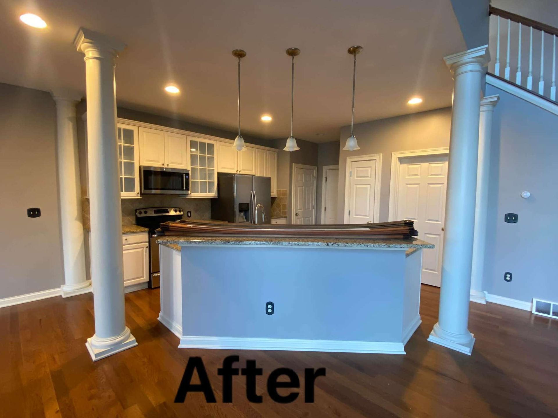 An empty living room with hardwood floors and a fireplace.