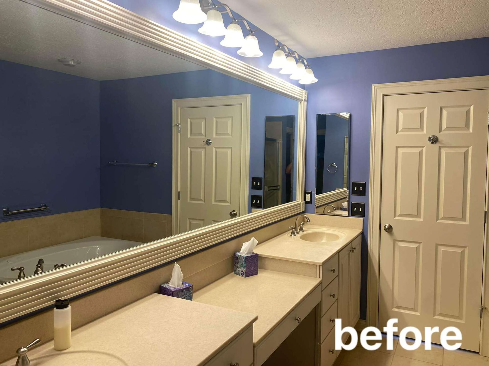 A before picture of a bathroom with two sinks and two mirrors