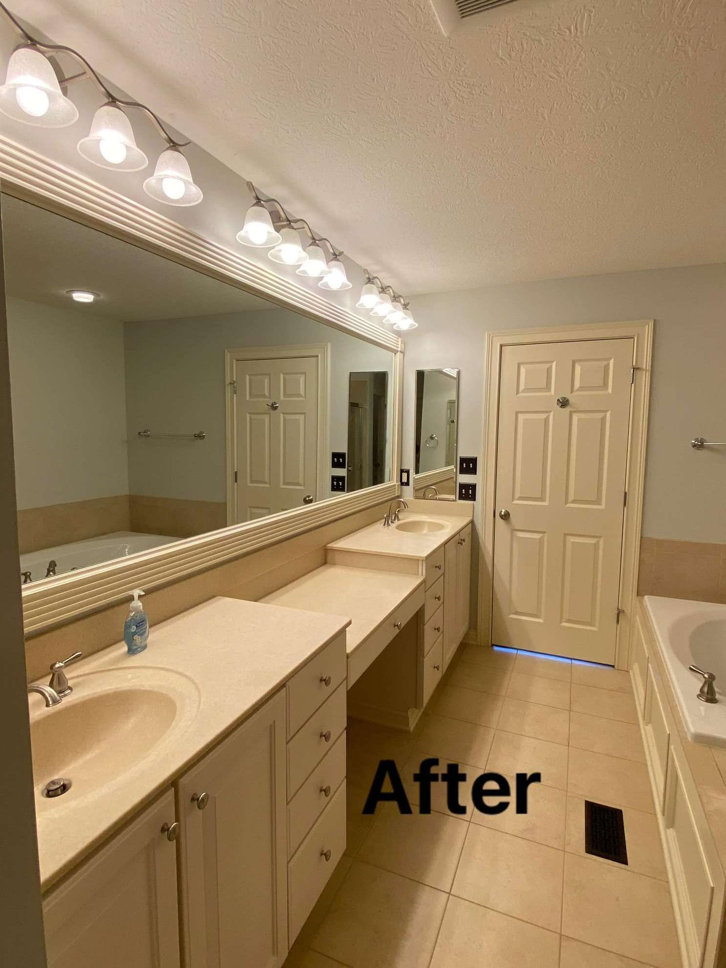 A bathroom with two sinks , two mirrors and a bathtub.