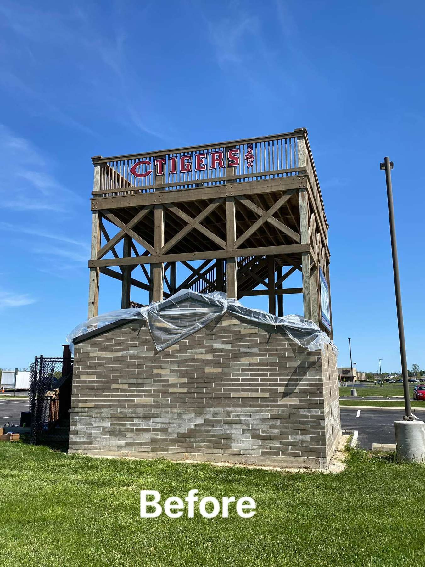 A before picture of a brick building with a wooden deck.