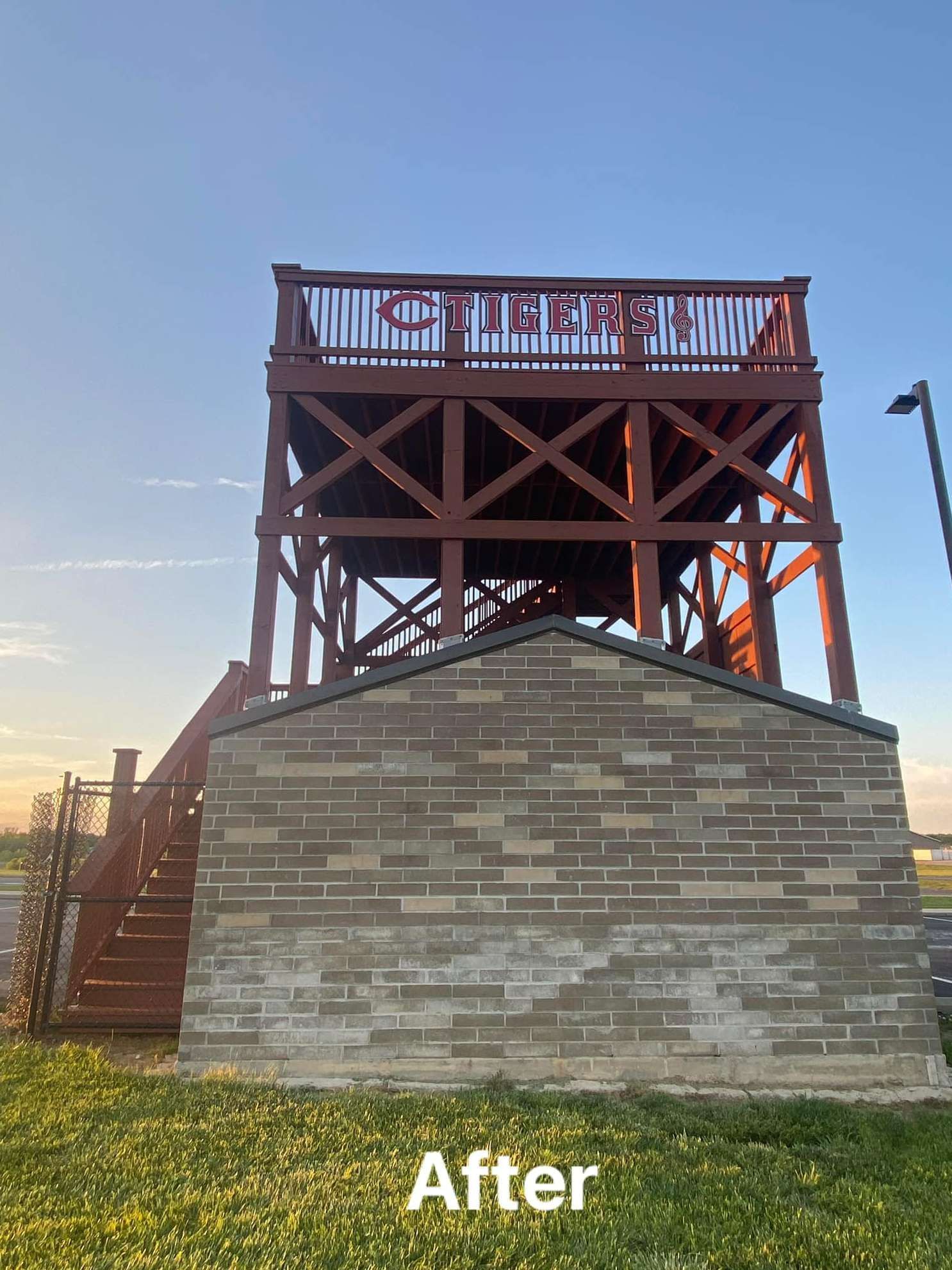 A picture of a brick building with a red deck and stairs.