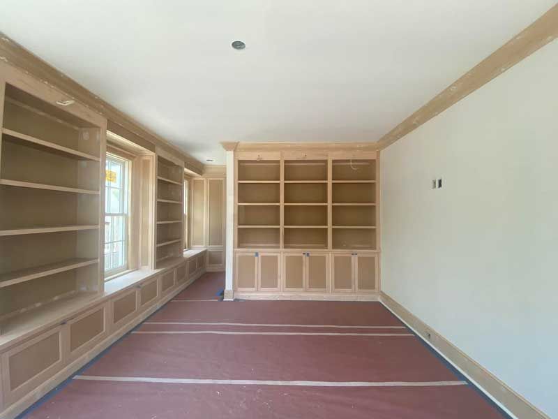 An empty room with lots of shelves and a window