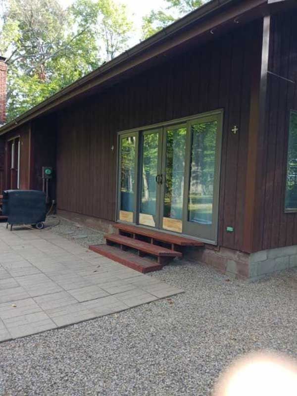 A house with sliding glass doors and a patio in front of it.
