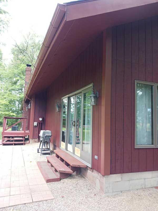 A red house with a patio and sliding glass doors