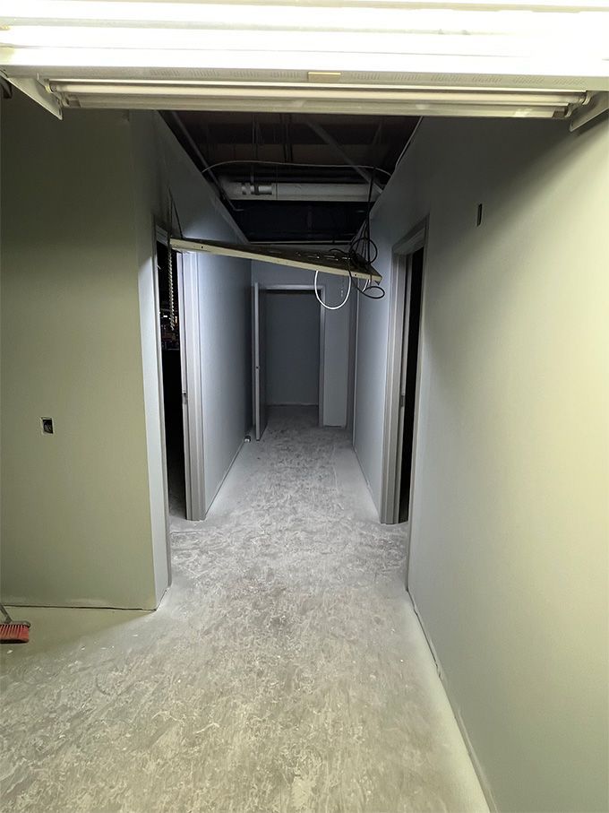 A long hallway with a light on the end of it.