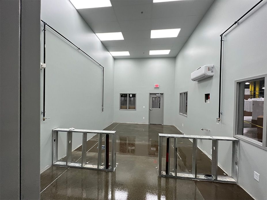 An empty room with white walls and a brown floor