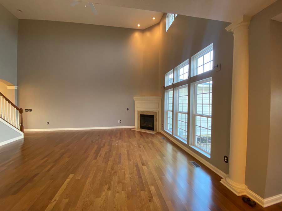 An empty living room with hardwood floors and a fireplace.