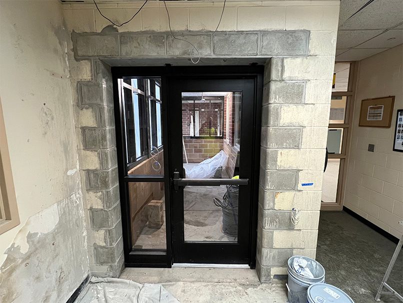 A door is being built into a brick wall in a building.