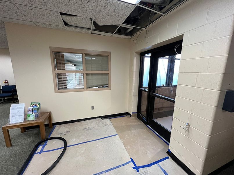 A room with a vacuum cleaner on the floor and a window.