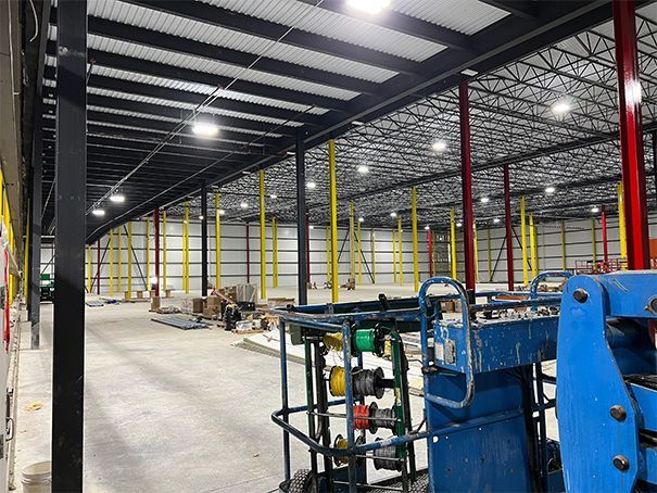 A large warehouse with a blue lift in the middle of it.