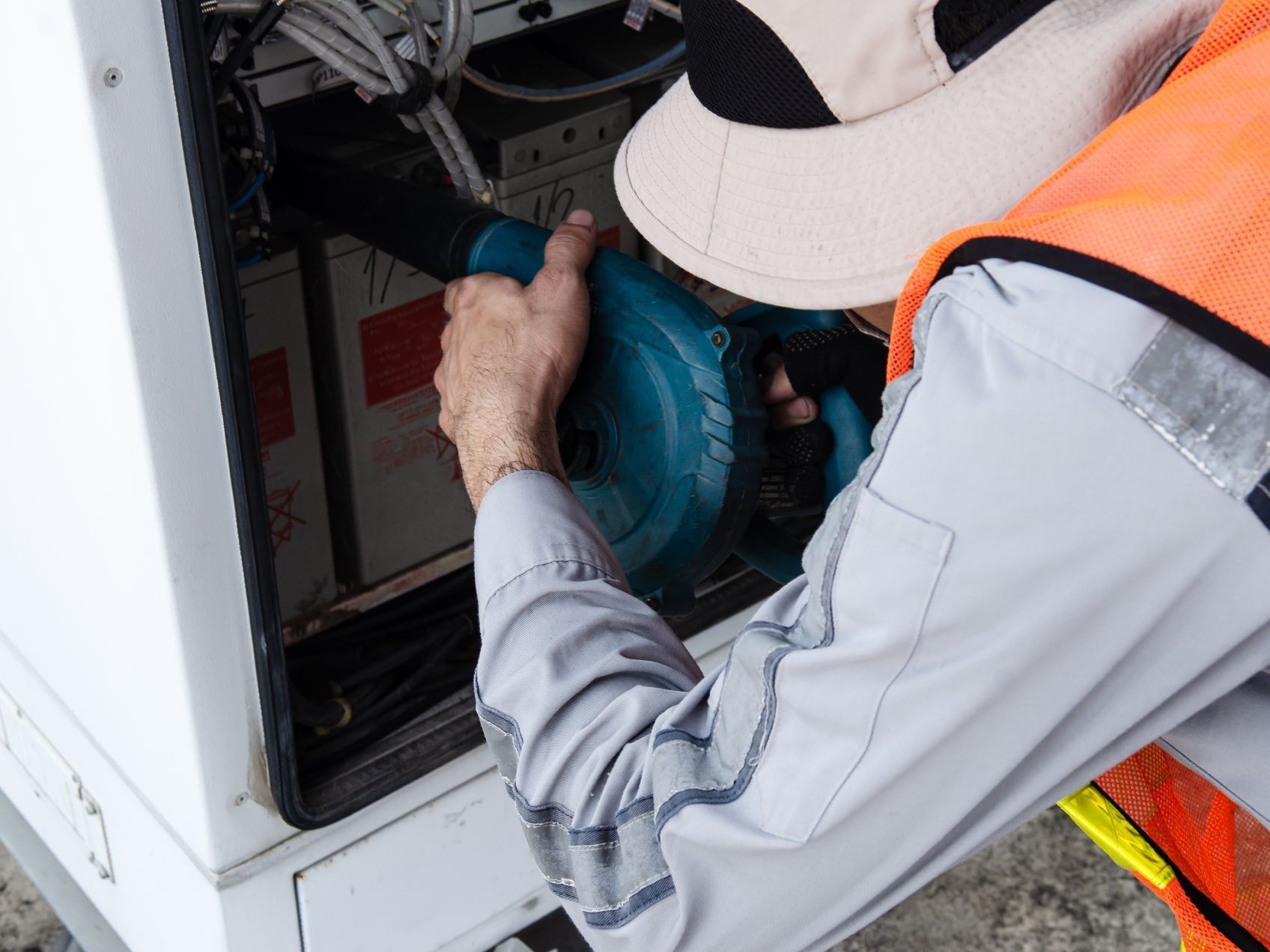 A man is working on a machine with a blower.