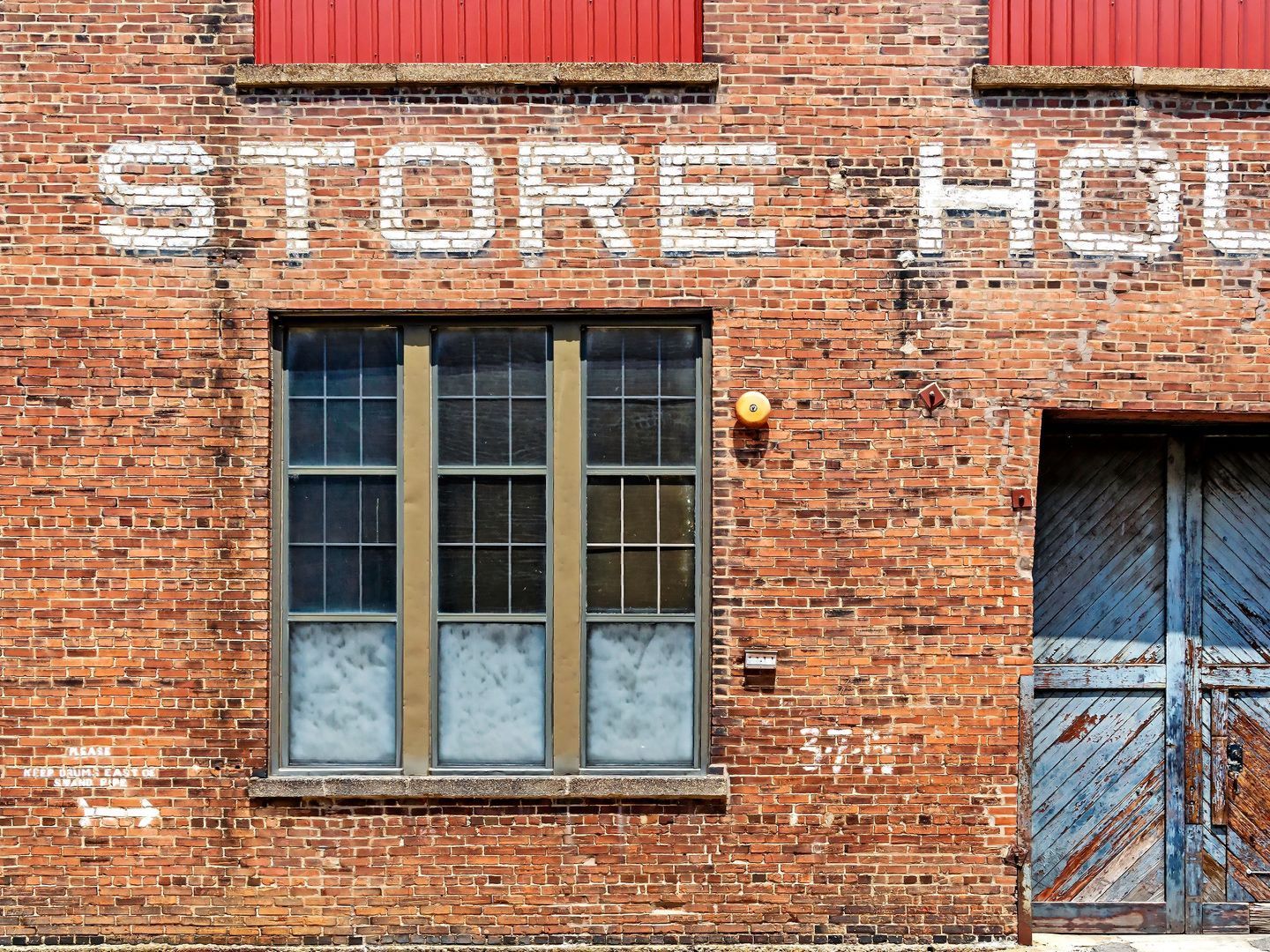A brick building with the words store house painted on it
