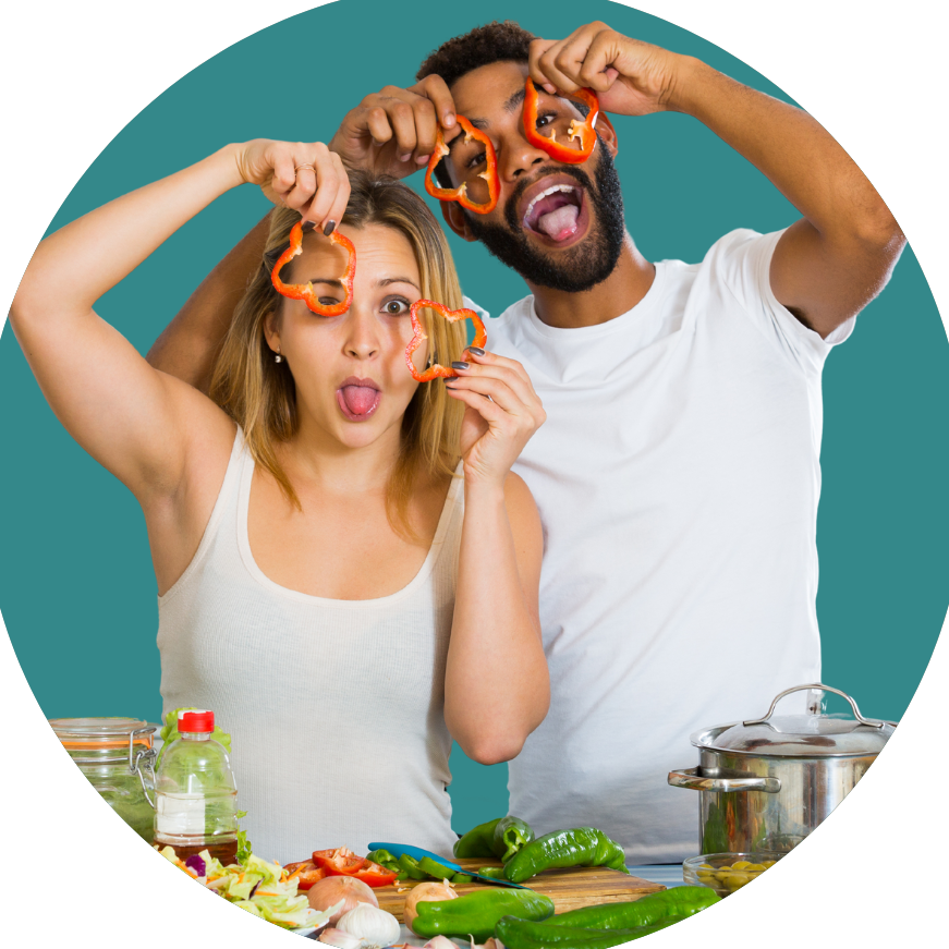 A man and a woman are holding peppers in front of their eyes