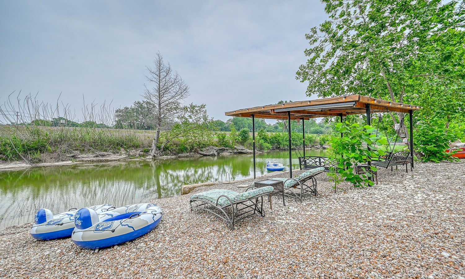 A couple of rafts sitting on top of a pile of gravel next to a body of water.