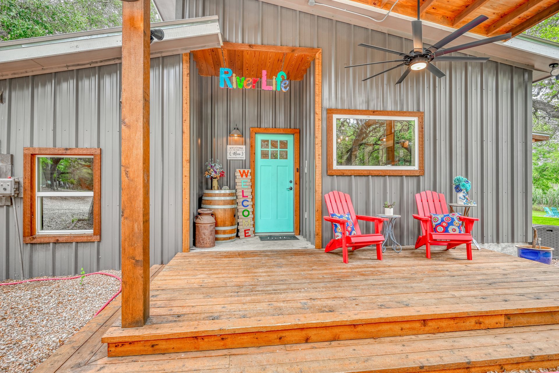 A house with a blue door and red chairs on the porch.