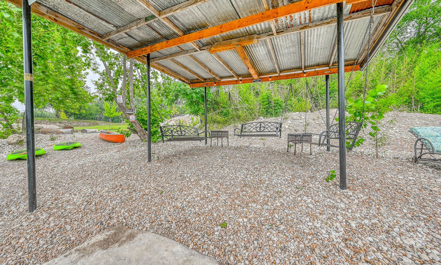 There is a covered area with benches and trees in the background.