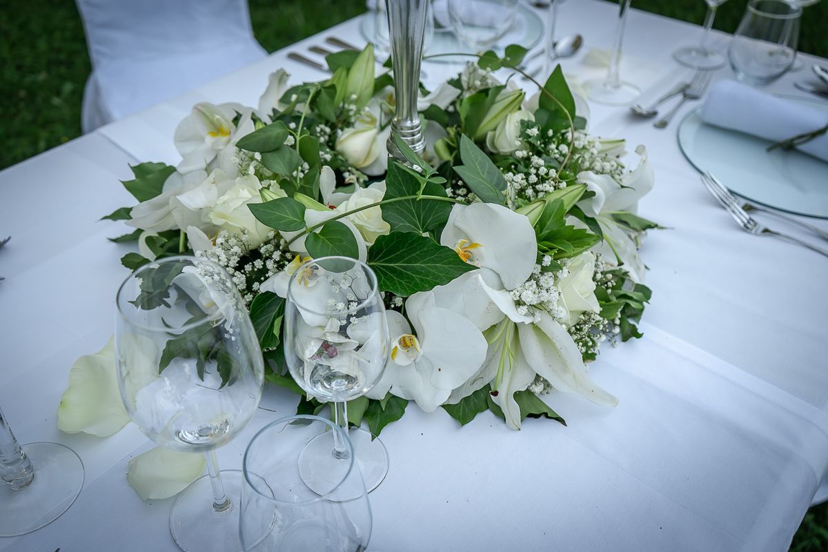 Ein Tisch mit Blumen und Weingläsern darauf