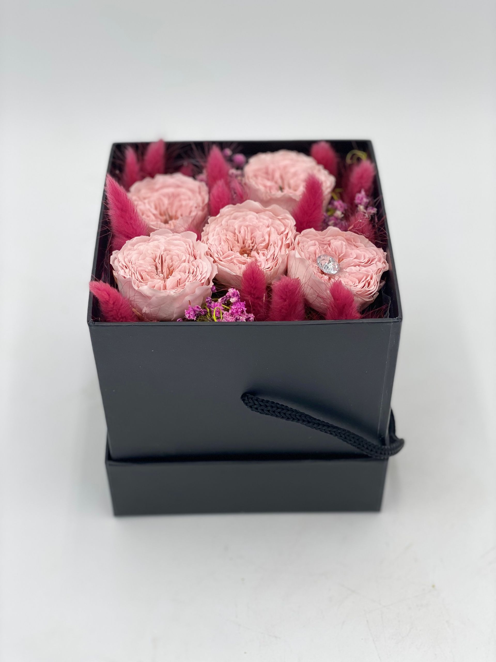 5 Stk.kleinblütige rosa Infinity Rosen in schwarzer Box mit dunkelrosa Trockengräsern.