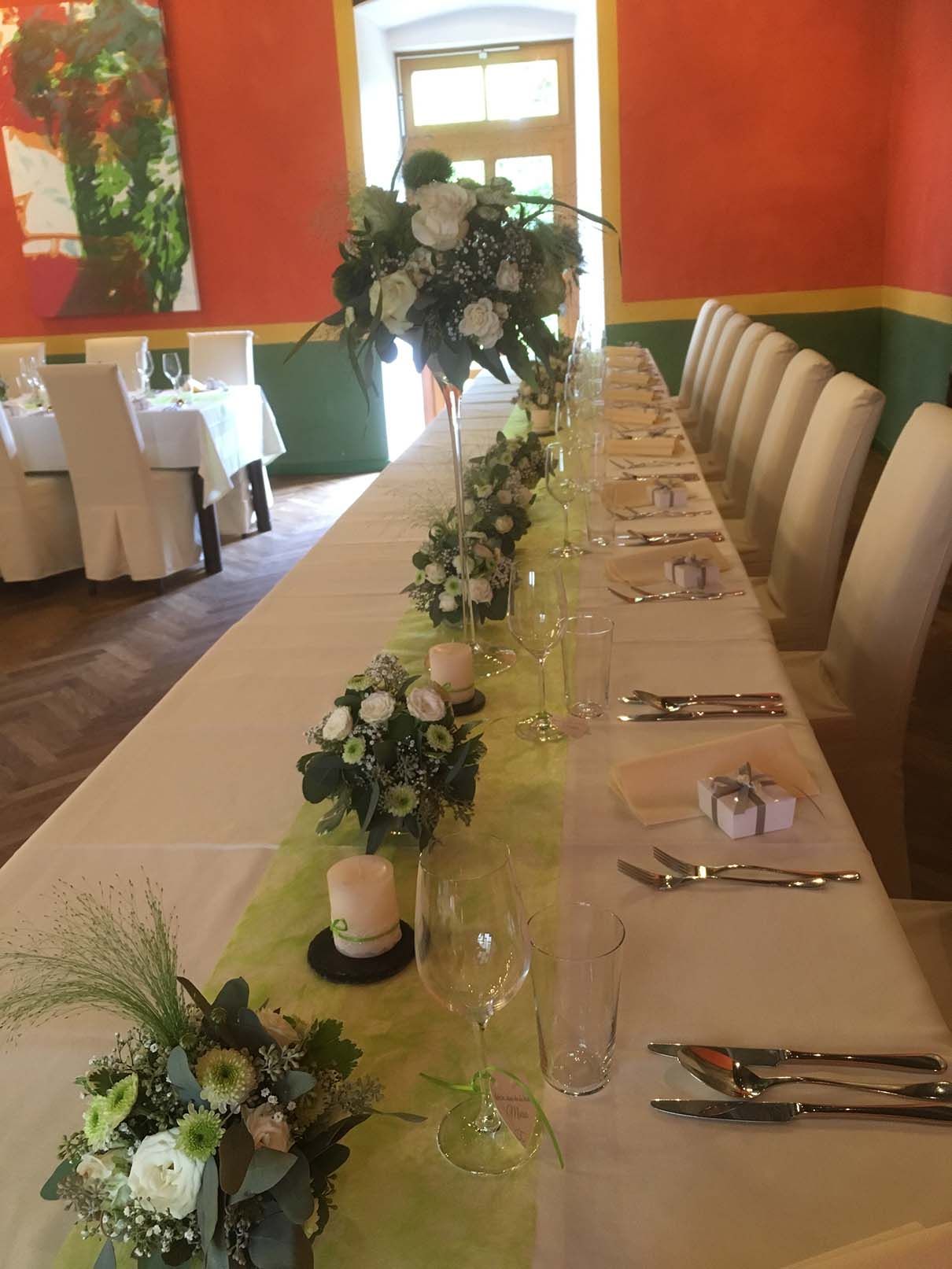 Ein langer Tisch mit Blumen und Kerzen darauf