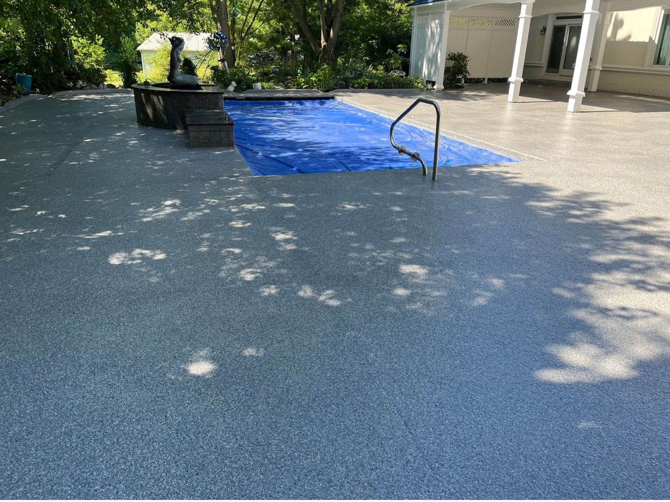 A large swimming pool is surrounded by a concrete deck.