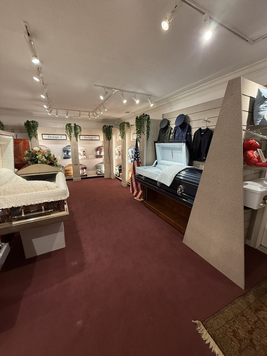 Boutique interior with burgundy carpet, white walls, string lights, and clothing racks and displays