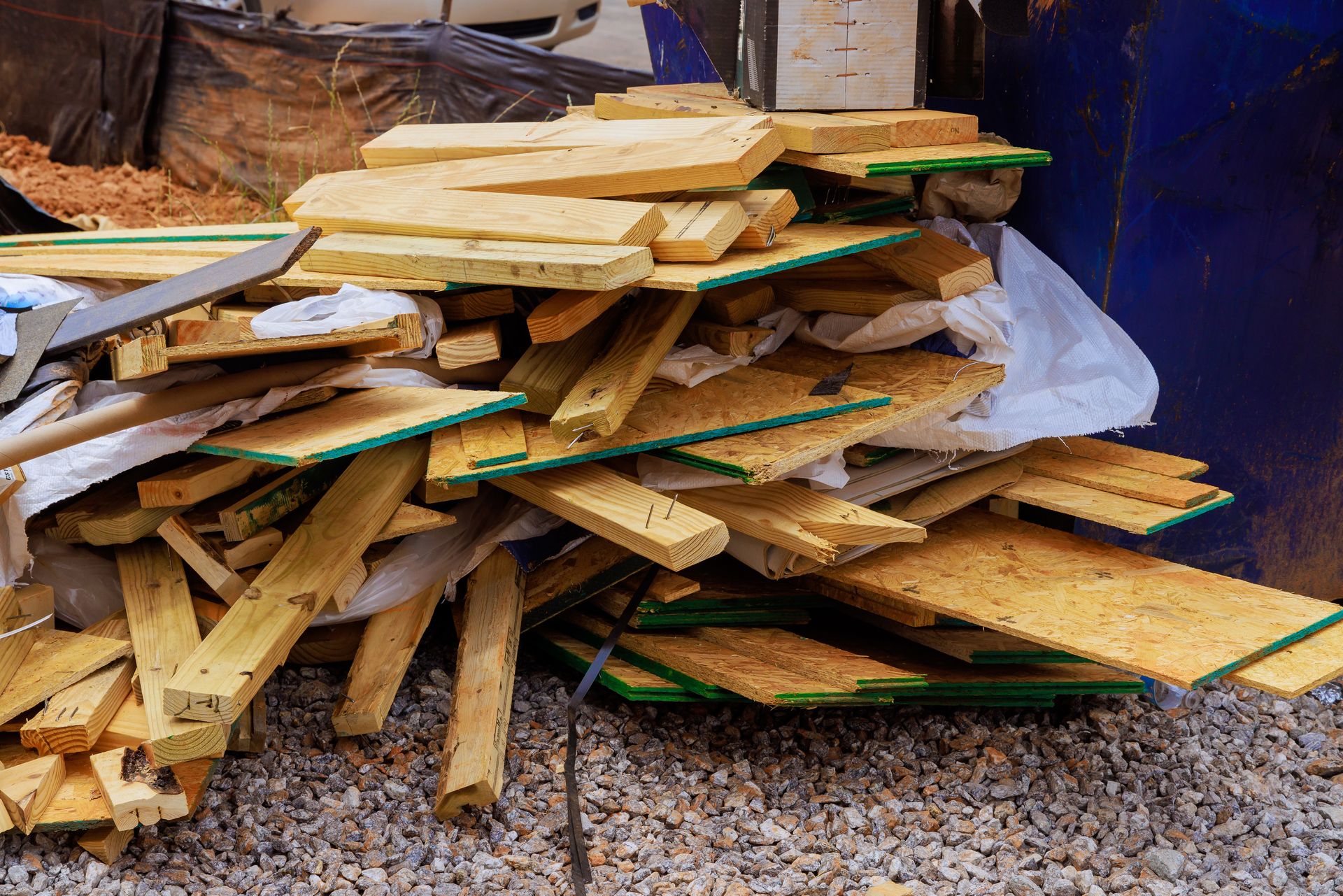A pile of wood is sitting on top of a pile of gravel.