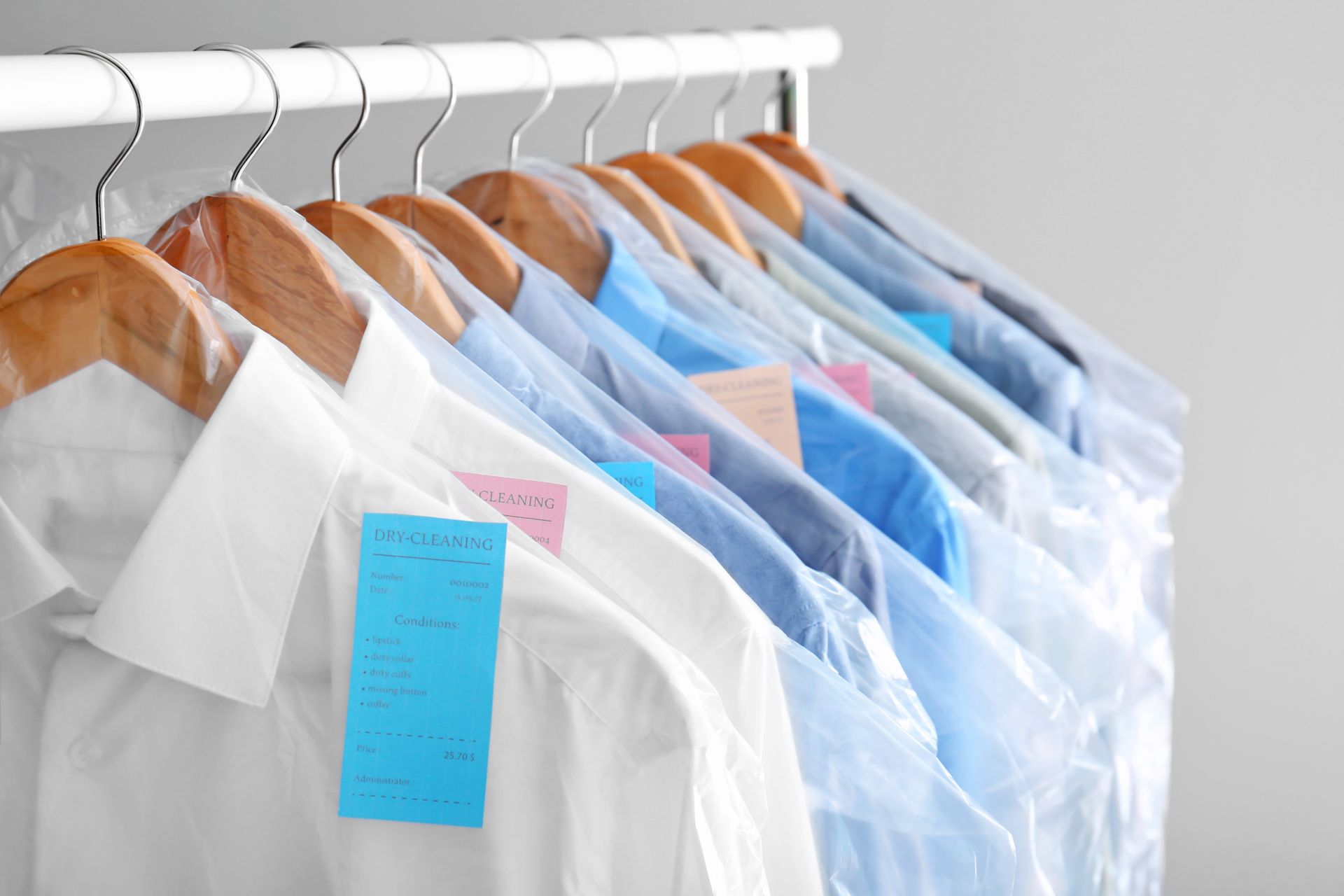 Shirts on wooden hangers in plastic dry-cleaning bags, on a rack. Shirts on wooden hangers in plastic dry-cleaning bags, on a rack.