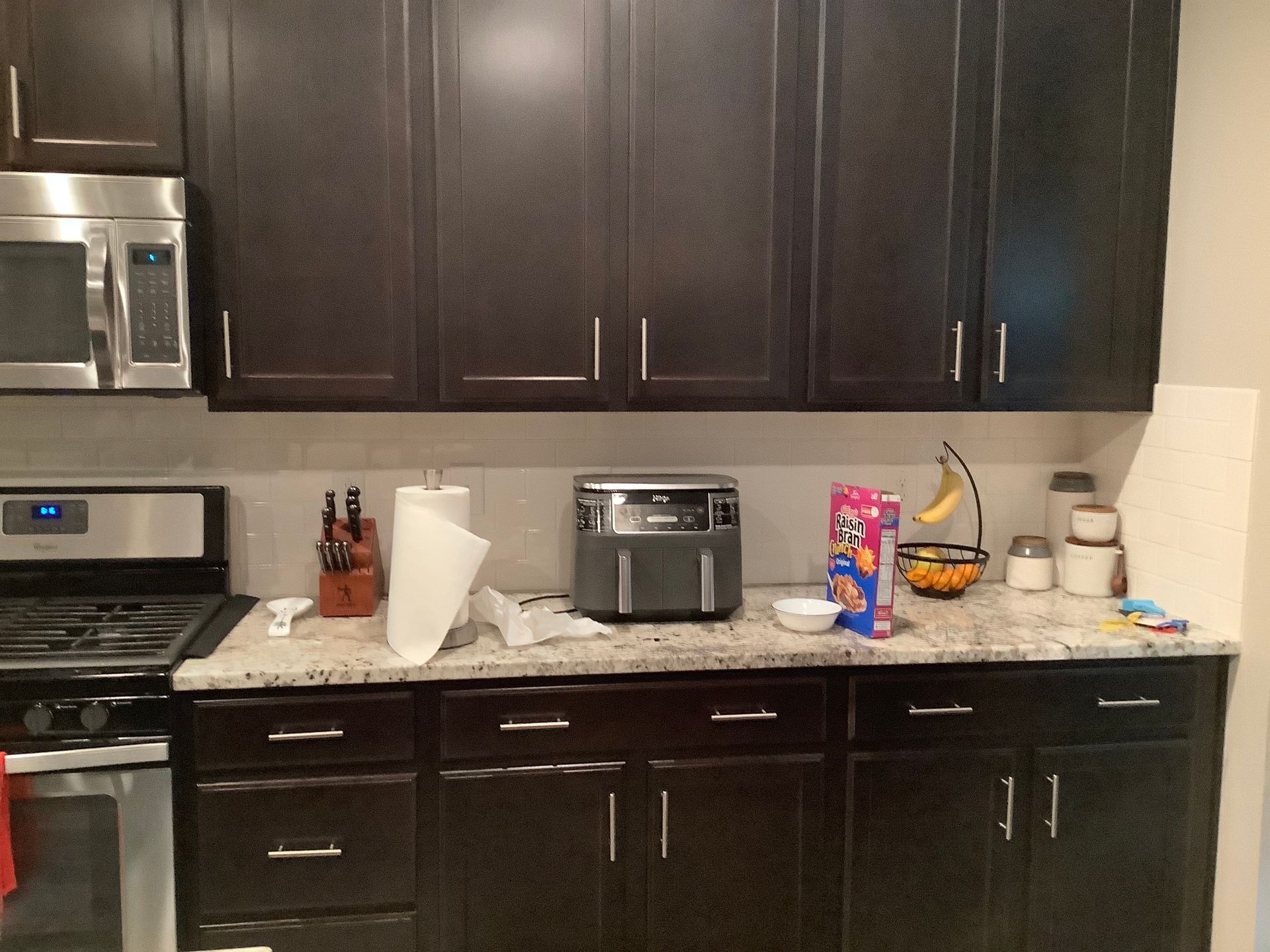 A kitchen with black cabinets and stainless steel appliances