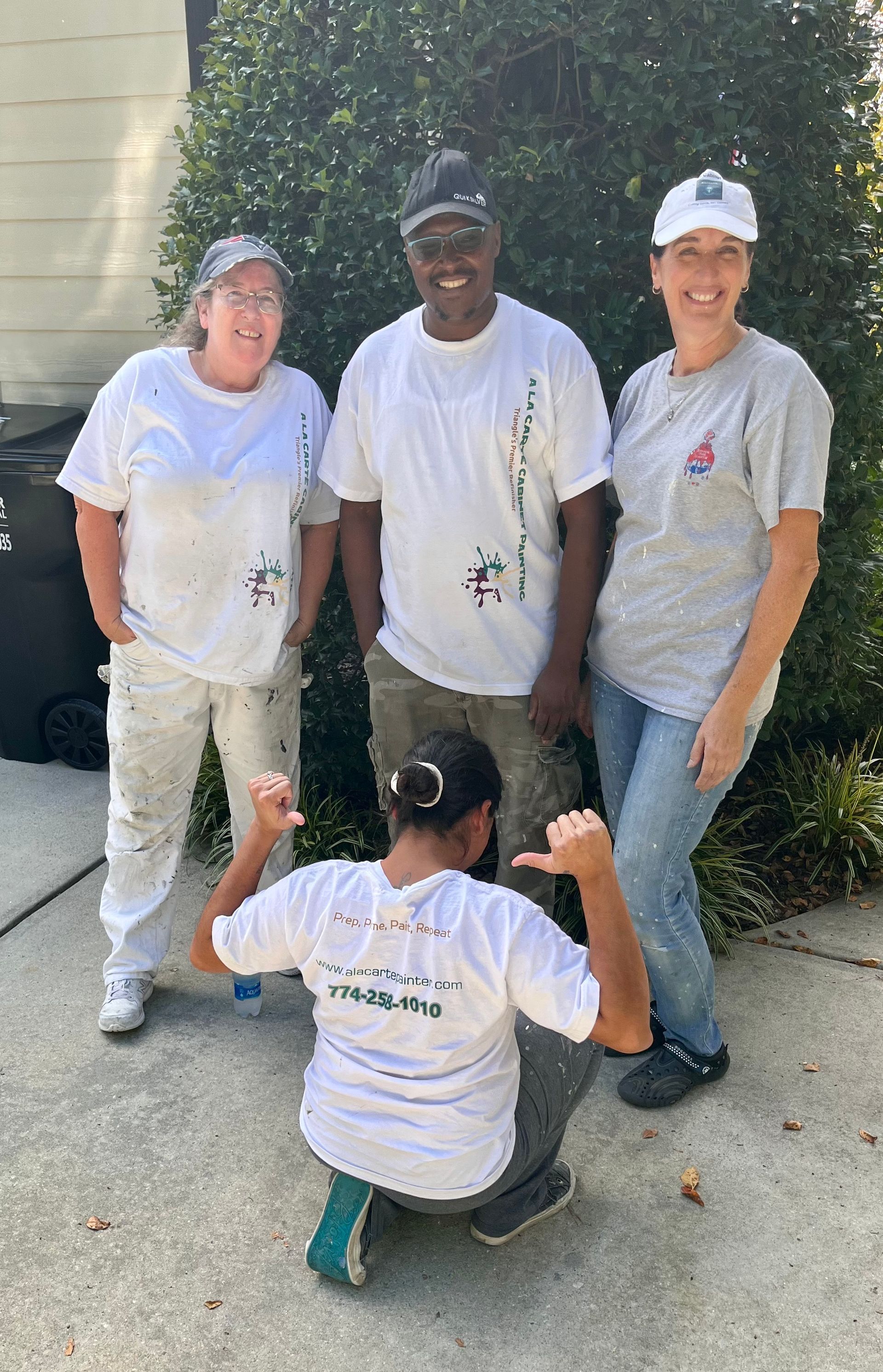 A group of people wearing white shirts are posing for a picture.