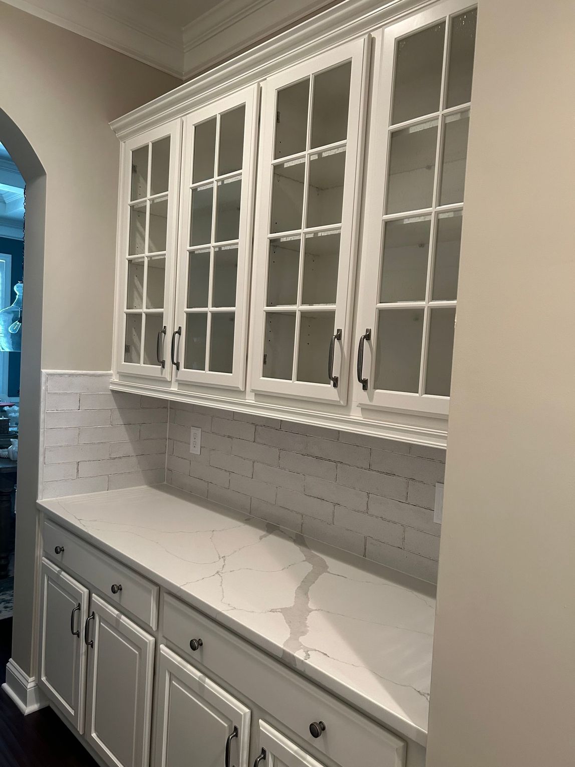 A kitchen with white cabinets and white counter tops.
