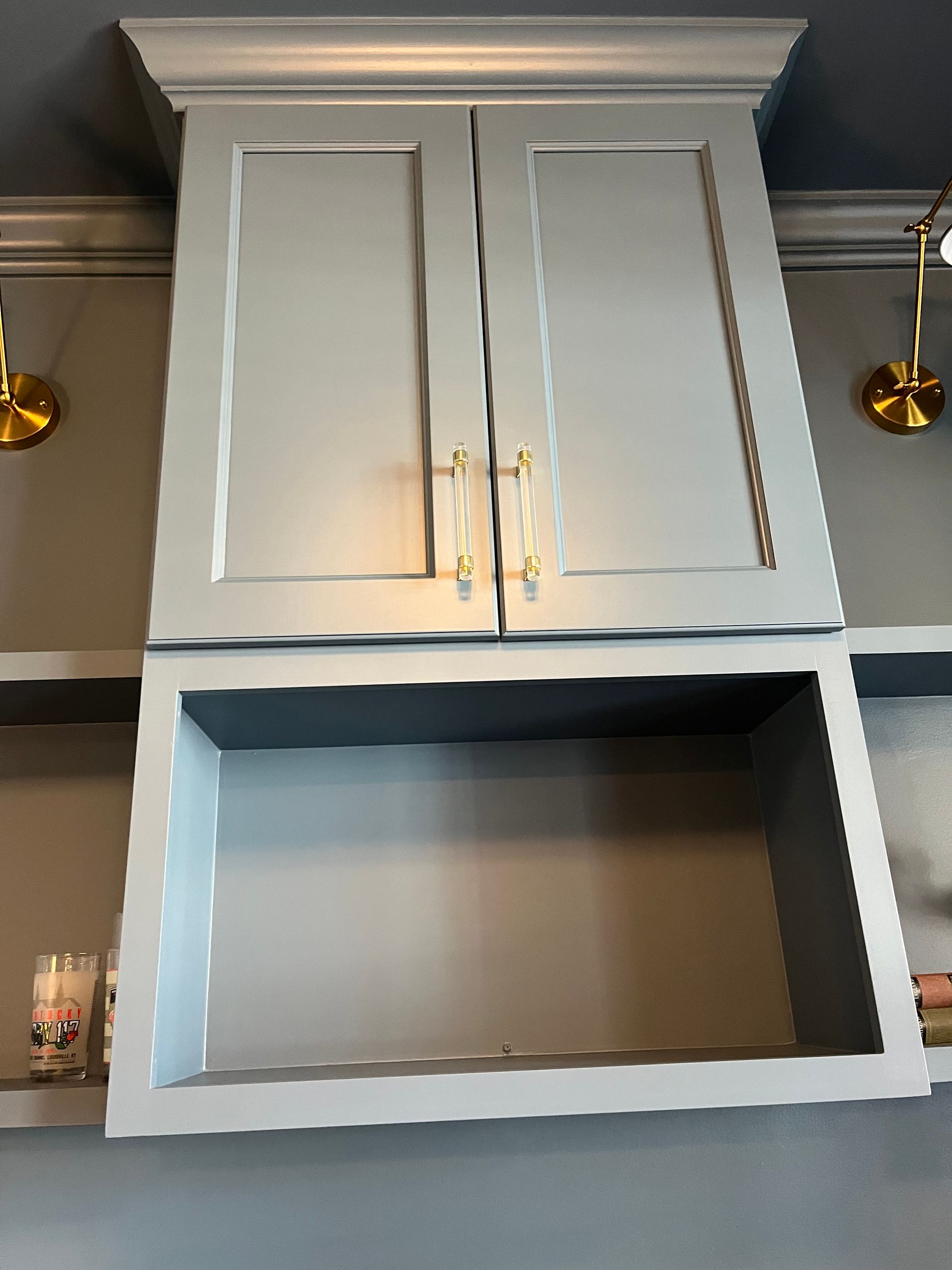 A gray cabinet with a shelf underneath it