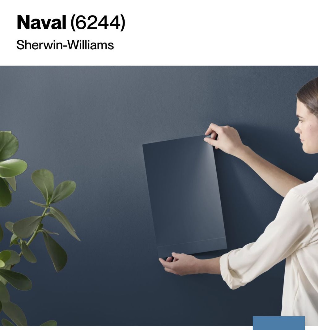 A woman is holding a piece of paper that says naval on it