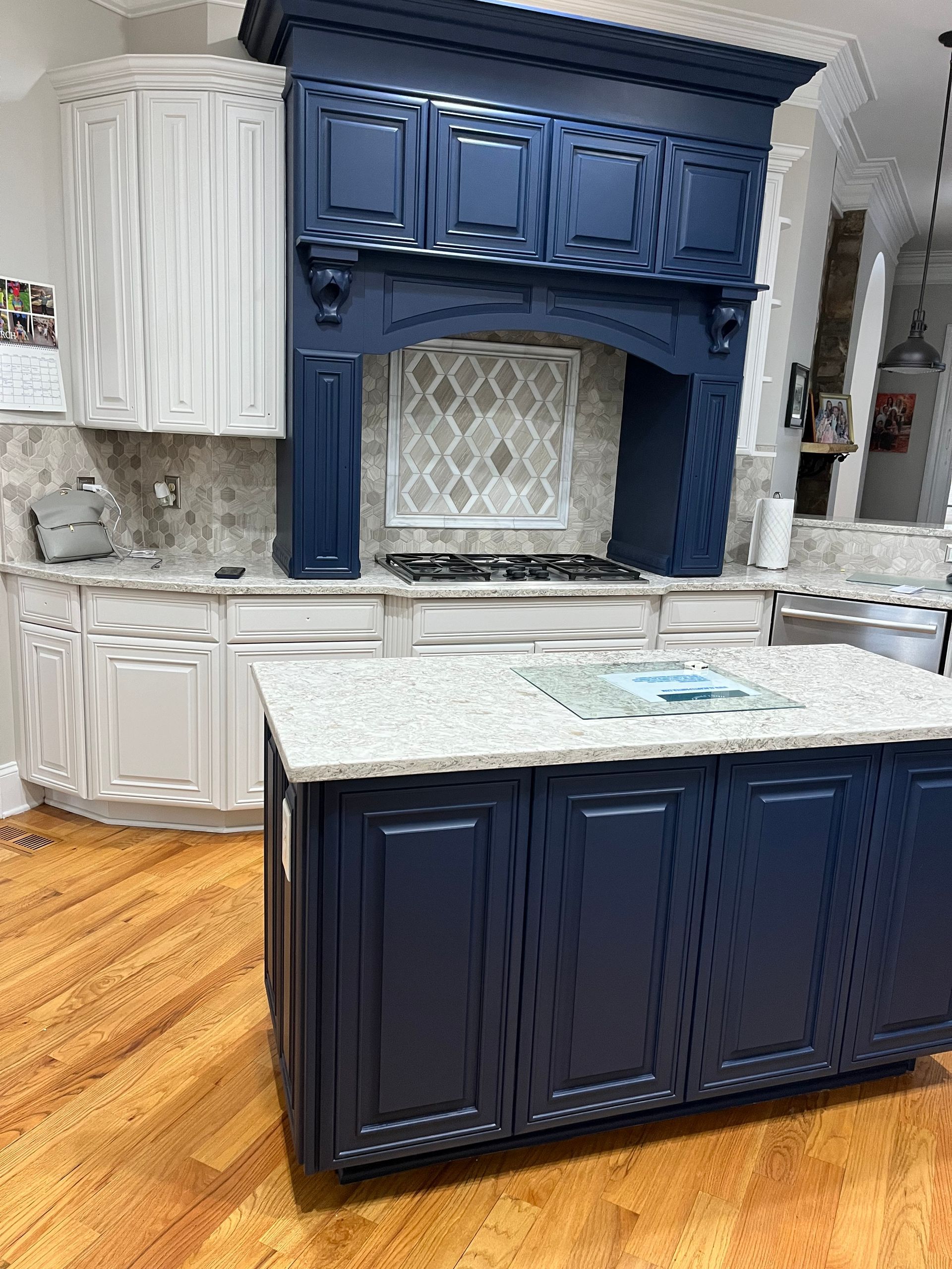 A kitchen with blue cabinets and white cabinets and a large island.
