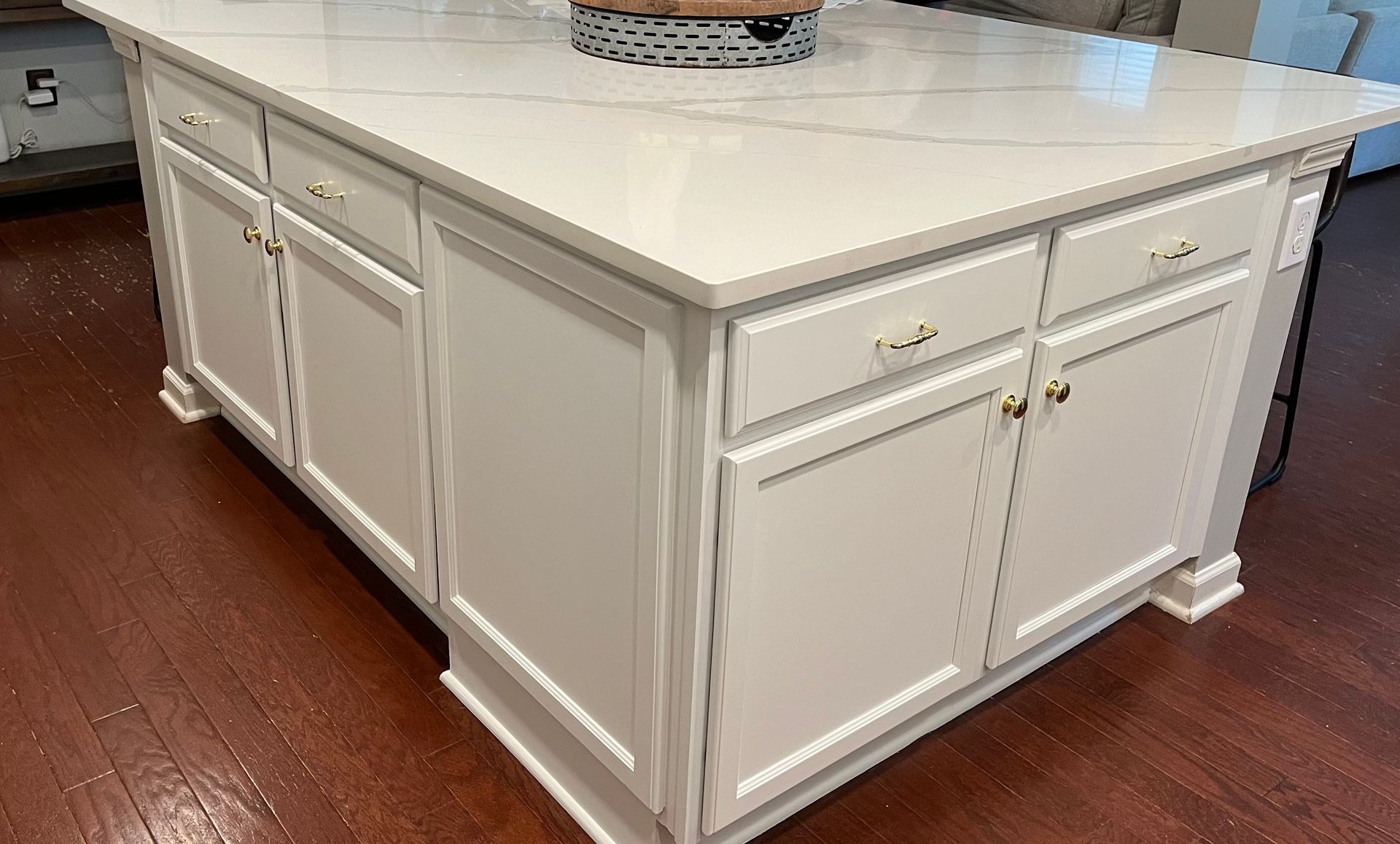 A kitchen island with white cabinets and a white counter top.