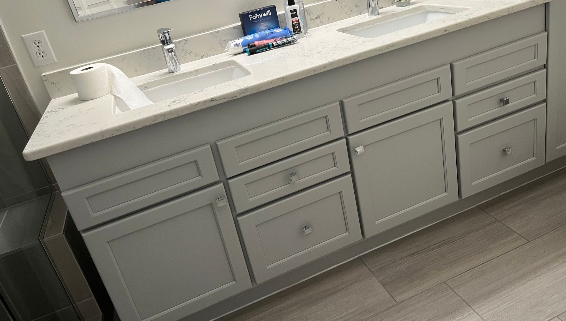 A bathroom vanity with two sinks and a mirror.