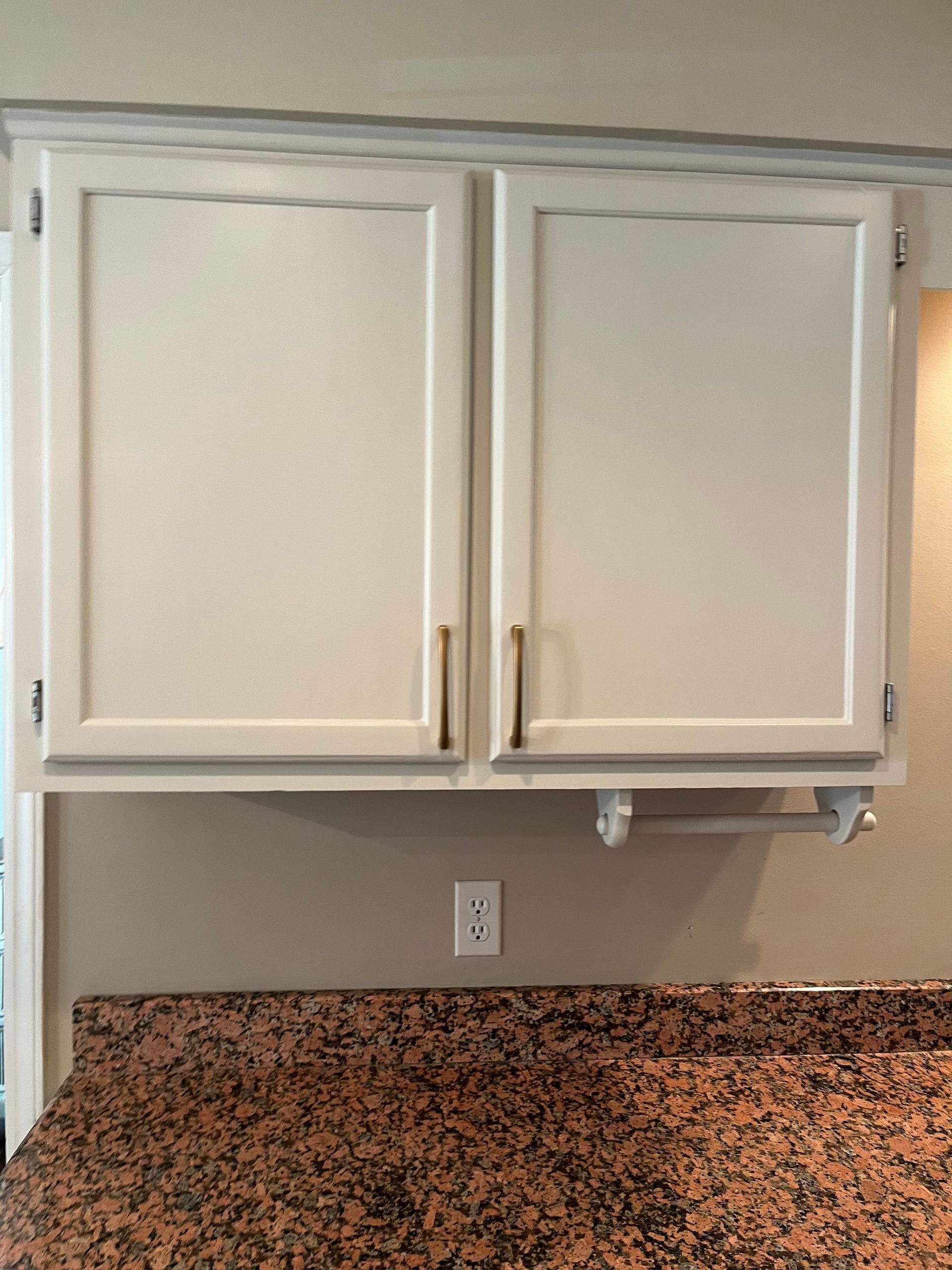 A kitchen with granite counter tops and white cabinets