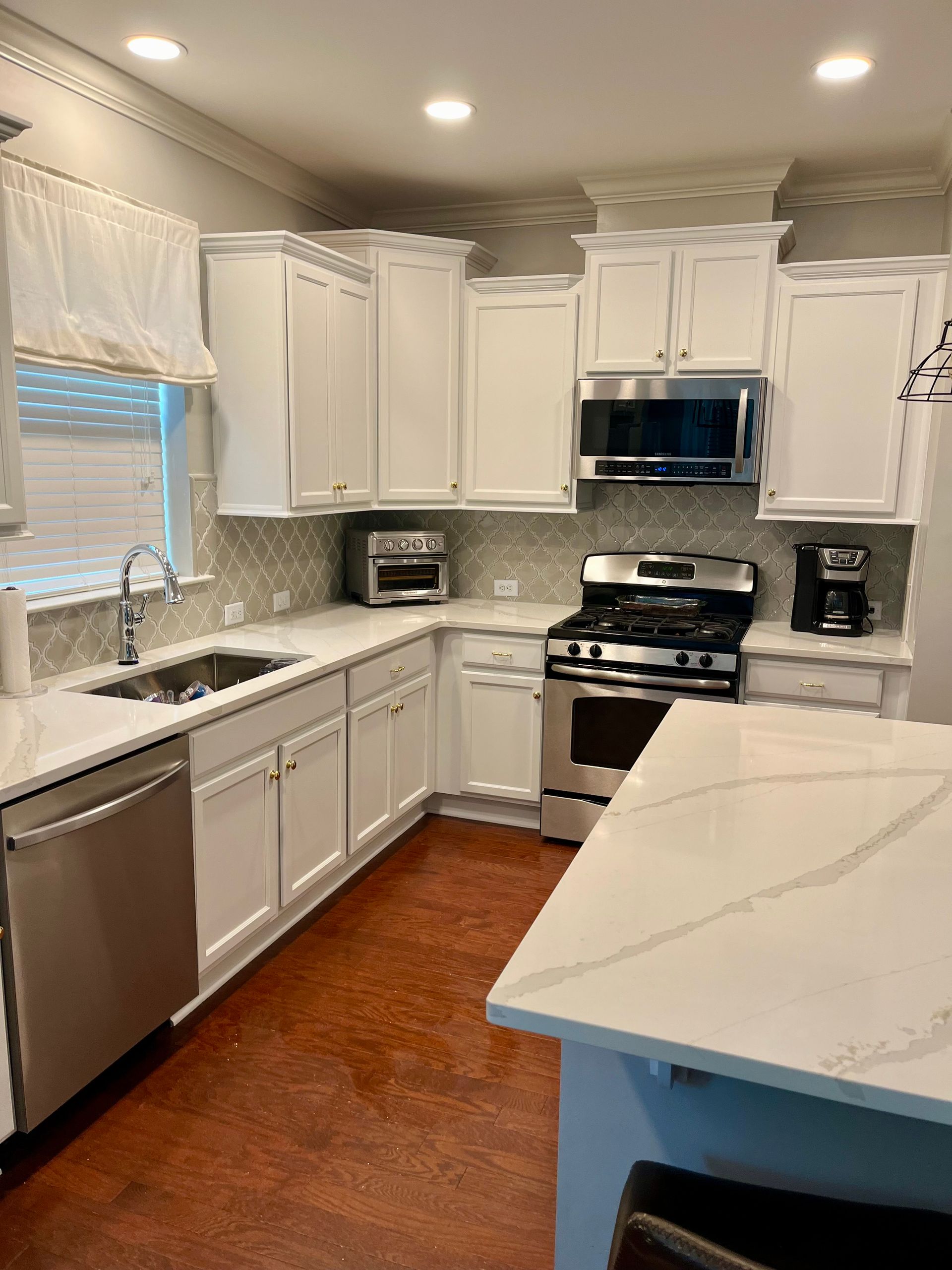 A kitchen with white cabinets and stainless steel appliances.